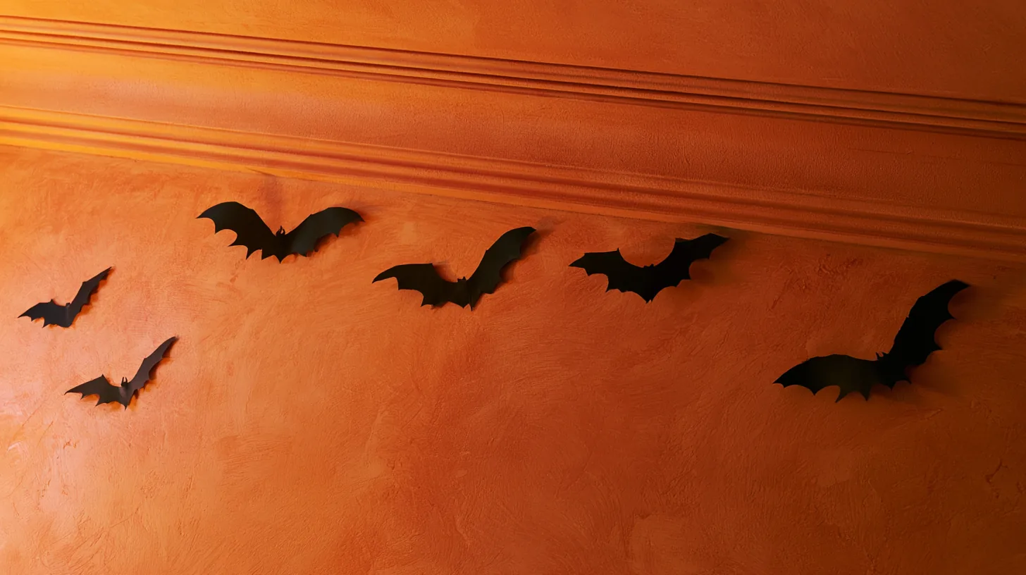 Textured orange wall featuring black bat decorations, suitable for a festive atmosphere.